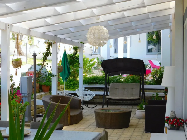 Un patio coperto con mobili da esterno e piante.