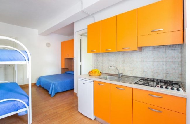 Cucina con letti a castello e armadio arancione.