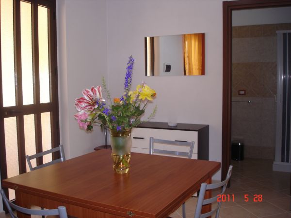 Tavolo in legno con vaso di fiori colorati in un angolo del soggiorno.