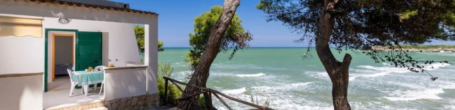 Balcone con vista mare e alberi.
