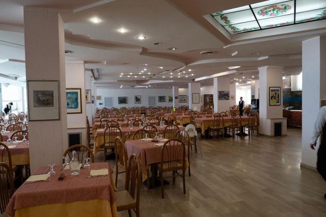 Ampia sala ristorante con tavoli apparecchiati.