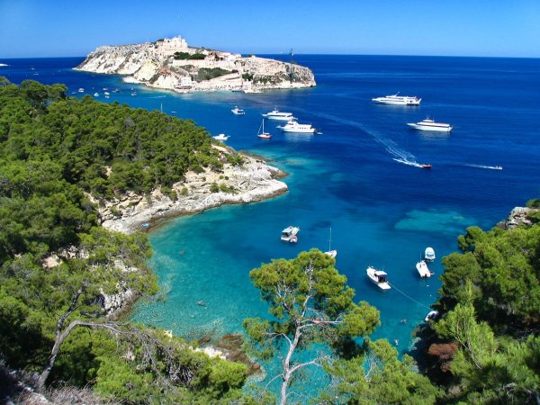 Vista panoramica su una baia con barche e vegetazione rigogliosa.
