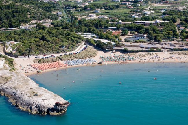 Spiaggia con ombrelloni colorati vista dall'alto.