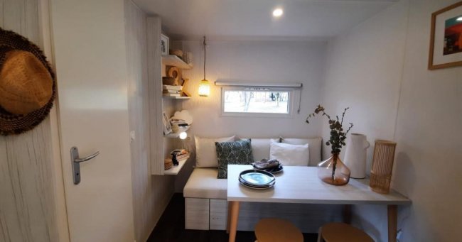 Tavolo compatto con seduta, mensole e decorazioni.