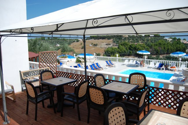 Terrazza con tavoli e piscina.
