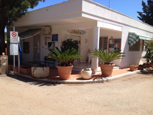 Edificio bianco con piante in vaso all'ingresso.