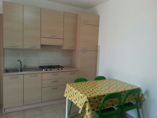 Cucina con tavolo e sedie verdi.