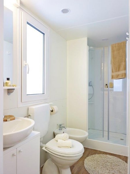 Bagno moderno con doccia e finestra.