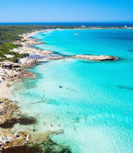 Spiaggia con acqua turchese vista dall'alto.