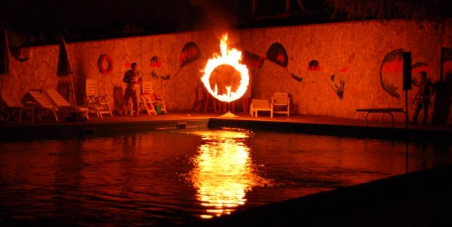 Cerchio infuocato di fronte a una piscina illuminata.