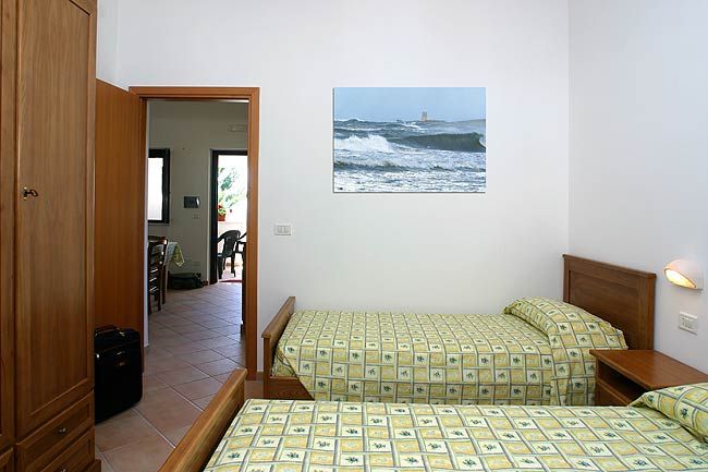 Camera con due letti singoli e quadro marino.