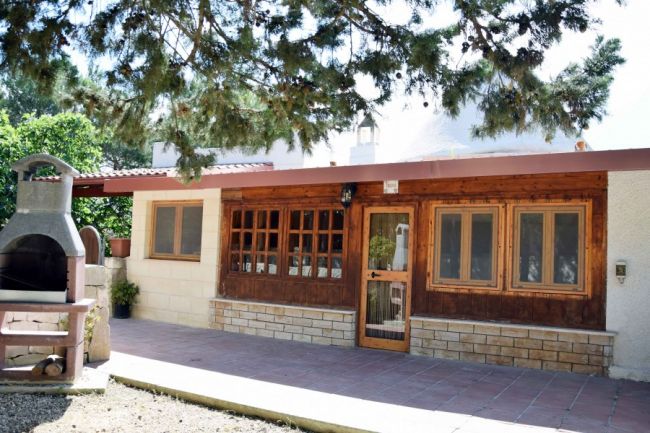 Esterno di una casa con grandi finestre in legno.