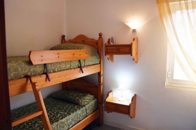 Letto a castello in legno in una stanza luminosa.