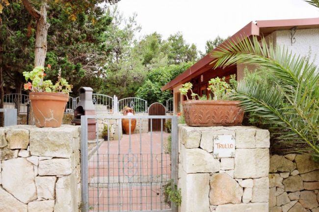 Ingresso giardino con vasi e piante.