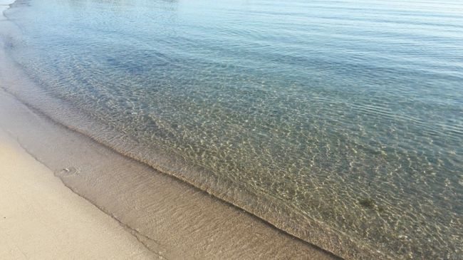 Spiaggia con sabbia fine e mare limpido.