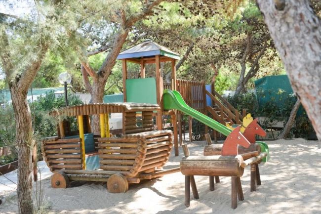 Un parco giochi in legno con scivolo verde.