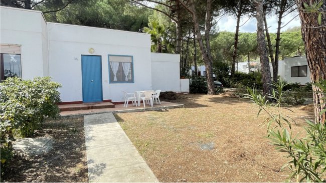 Villetta bianca con porta blu, tavolo all'aperto.