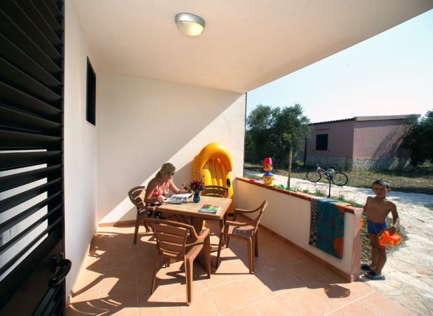 Terrazza con tavolo e sedia, bambino fuori.