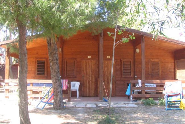 Casetta di legno con sedie e asciugamani fuori.