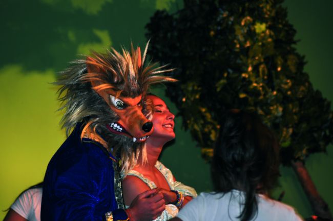 Figura in costume da lupo con una persona sorridente.