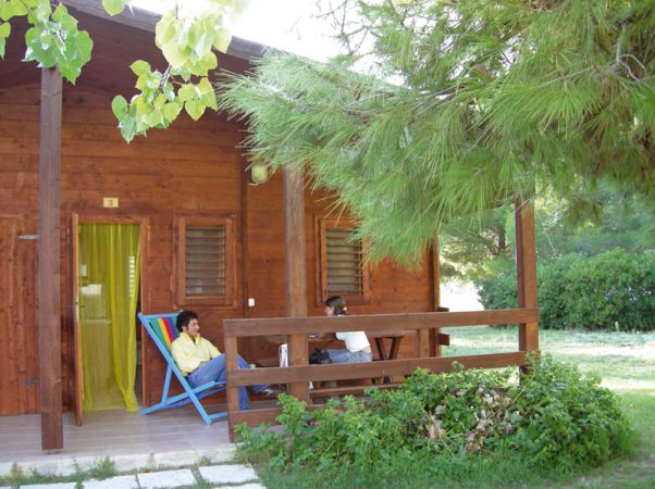 Due persone sedute su una veranda di legno.