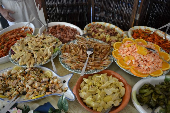 Un buffet pieno di diversi piatti di pesce e verdure.