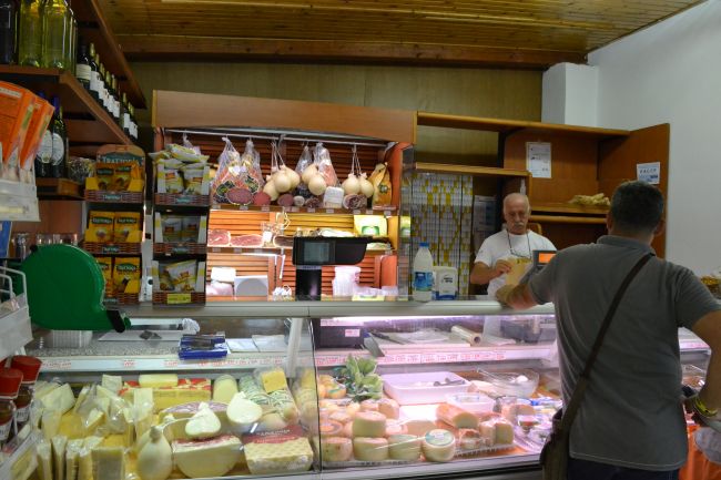 Negozio di alimentari con formaggi e salumi esposti.
