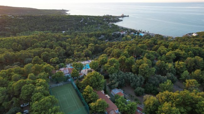 Vista aerea di un campo sportivo e la costa.