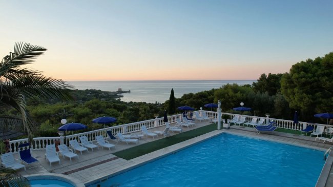 Piscina con vista mare al tramonto.