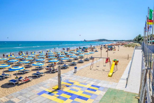 Spiaggia con ombrelloni blu e gialli.
