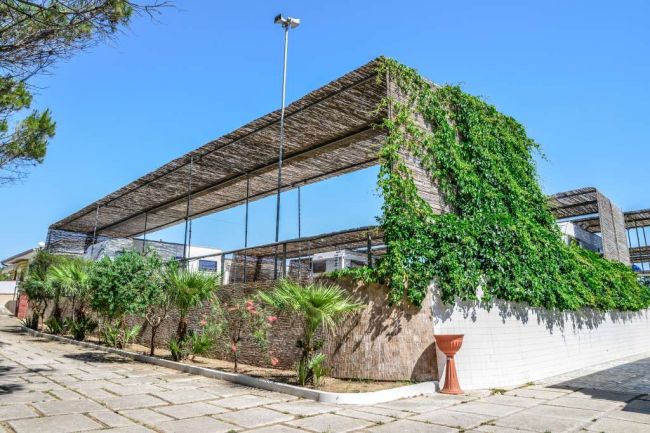 Struttura con pergola e verde, viali pavimentati.